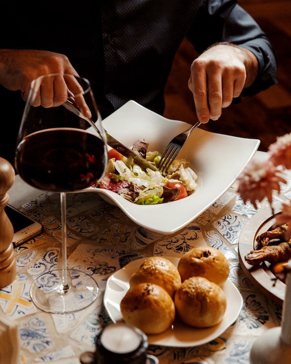 Bezpłatny plik Zdjęcie mężczyzna jedzenie sałatki wołowej z sałatą i pomidorem w restauracji