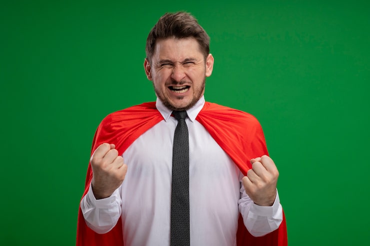 Bezpłatny plik Zdjęcie superbohater biznesmen w czerwonej pelerynie zaciskając pięści emocjonalny i podekscytowany stojąc na zielonym tle