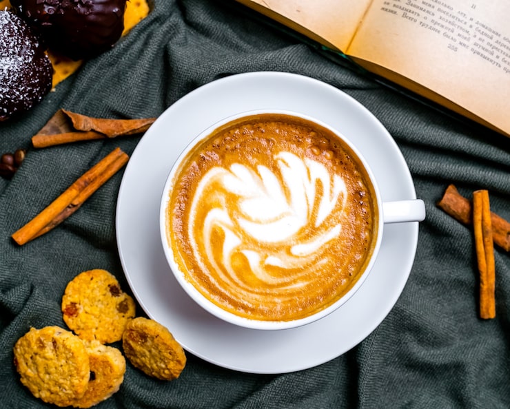 Bezpłatny plik Zdjęcie widok z góry filiżankę cappuccino z ciasteczkami i książką na stole
