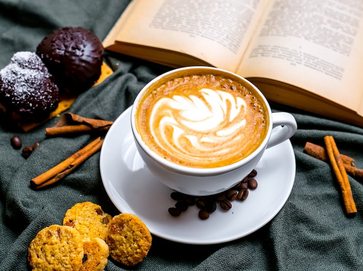 Bezpłatny plik Zdjęcie widok z góry filiżankę cappuccino z czekoladowymi ciasteczkami i rodzynkami i książką na stole