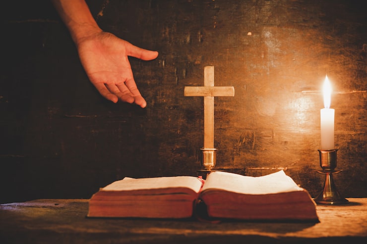 Foto gratuito abra la biblia santa y la vela en una tabla de madera del roble viejo.
