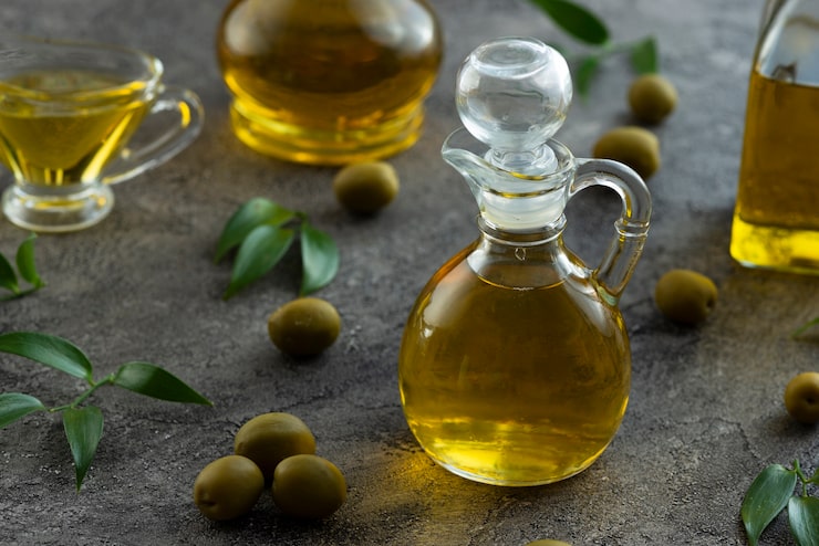 Foto gratuito alta vista de botellas llenas de aceite de oliva sobre fondo de mármol