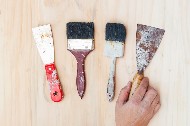 Foto gratuito antiguas herramientas de mano de pintura con mano sobre fondo de madera