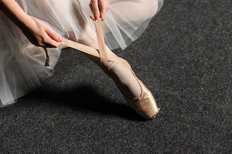 Photo Gratis balerina mengikat pita sepatu pointenya