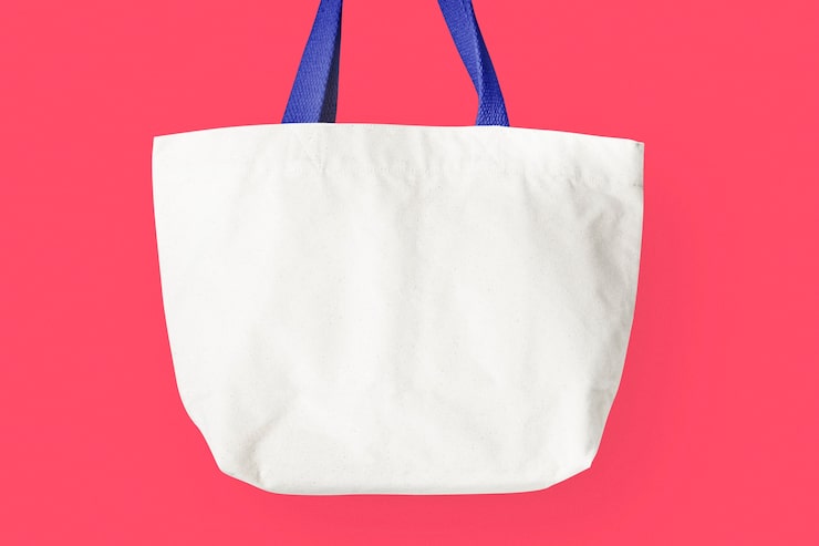 Foto gratuito bolso blanco sobre un fondo rosado