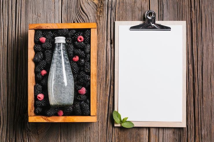 Photo Gratis botol jus blackberry di kotak kayu dengan clipboard