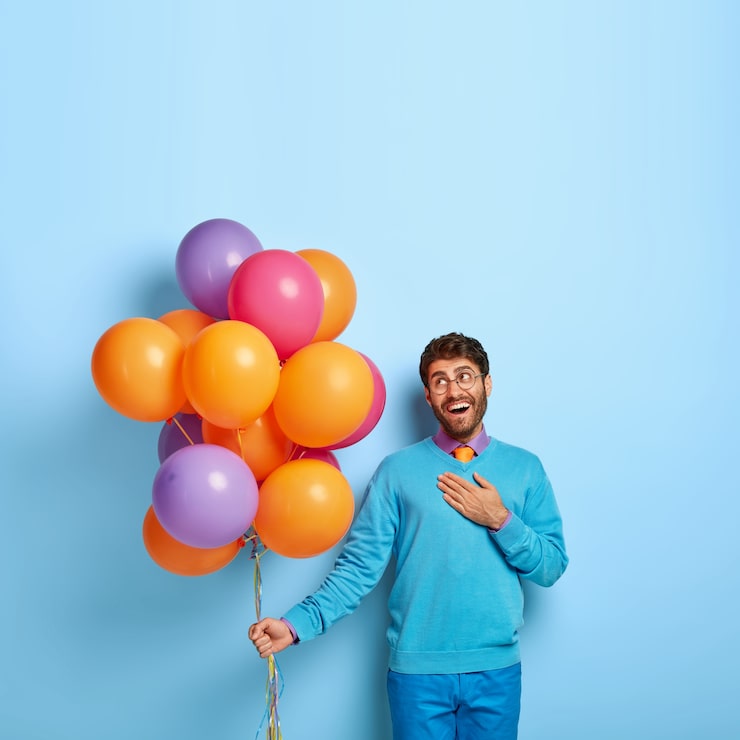 Foto gratuito celebración de la fiesta de cumpleaños. tocado chico complacido mantiene la palma en el pecho