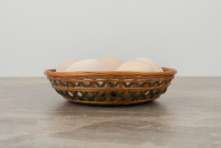 Foto gratuito cesta de huevos blancos sobre mesa de mármol.