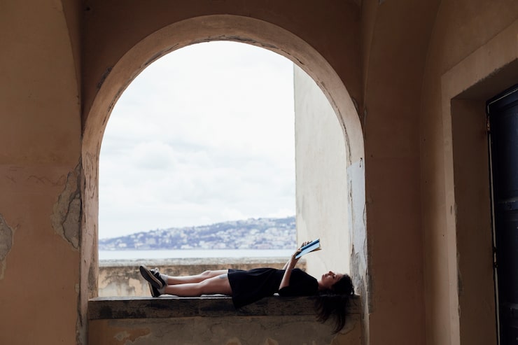 Foto gratuito chica leyendo un libro boca arriba