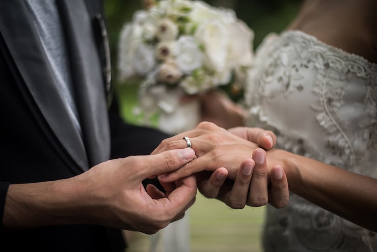 Photo Gratis close up pengantin pria memasangkan cincin ke pengantin wanita di hari pernikahan. konsep cinta, bahagia menikah.