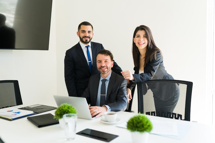 Foto gratuito compañeros de trabajo atractivos que se sienten felices mientras trabajan en un proyecto empresarial en la sala de reuniones. empresarios y colegas haciendo trámites