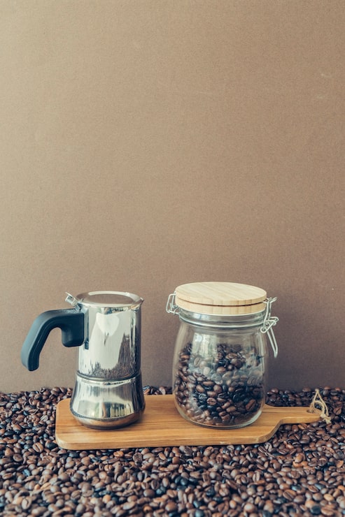 Foto gratuito composición de café con cafetera y jarra en tabla