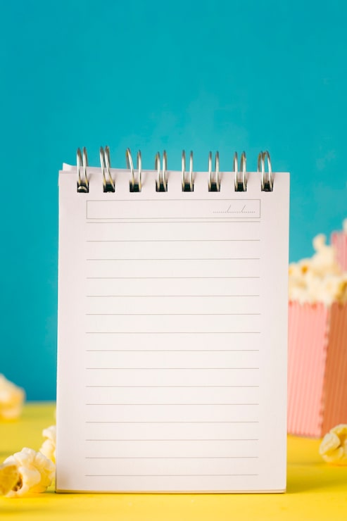 Foto gratuito composición de cine con libreta vacía