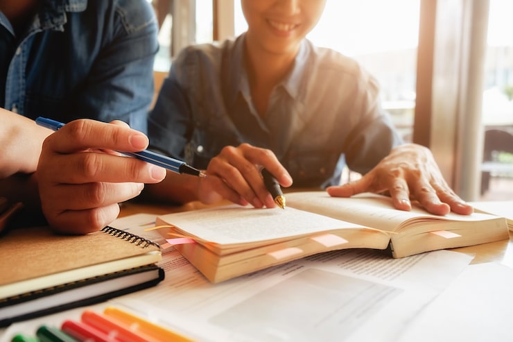 Foto gratuito concepto de educación. estudiante, estudiar, brainstorming, campus, concepto cerca de los estudiantes que discuten su tema en libros o libros de texto. enfoque selectivo.