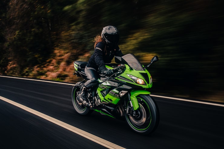 Foto gratuito conducir motocicleta verde en la carretera.