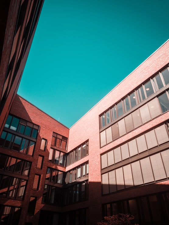 Foto gratuito edificio de hormigón marrón y cielo azul claro