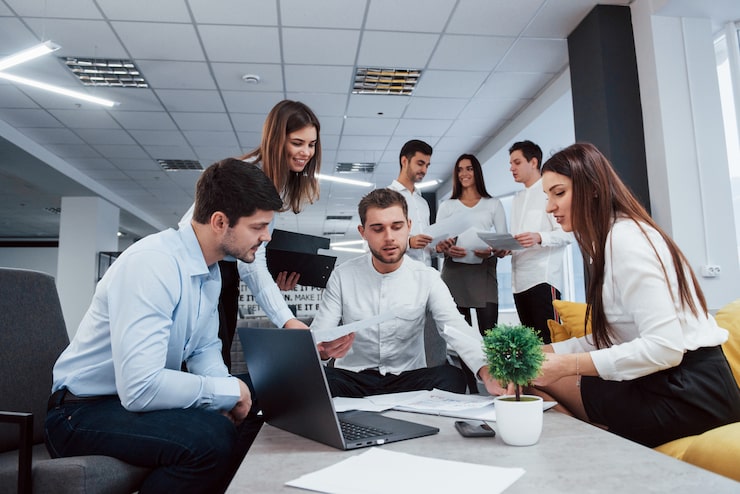 Foto gratuito elaboración de plan de negocios. grupo de jóvenes autónomos en la oficina conversando y sonriendo