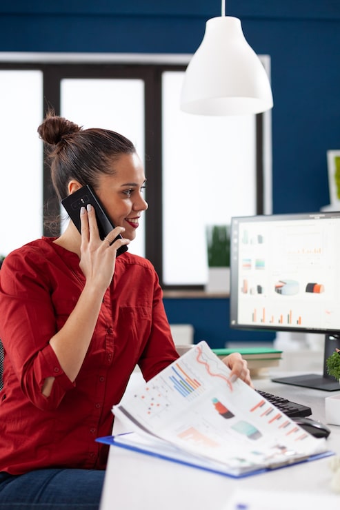 Foto gratuito la empresaria haciendo una llamada con smartphone sentados frente al escritorio