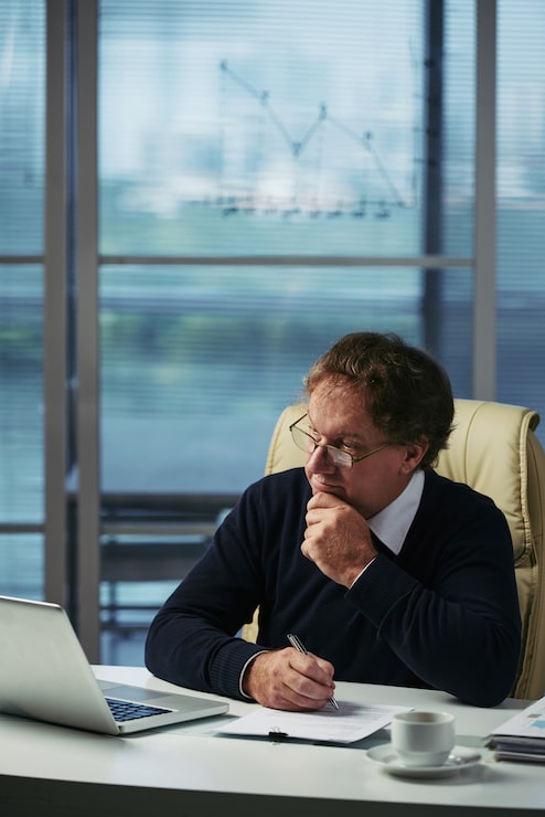 Foto gratuito empresario analizando información financiera en su oficina