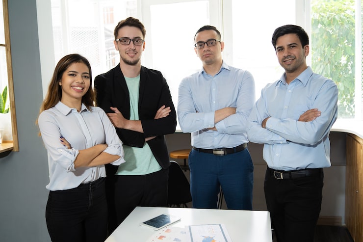 Foto gratuito equipo de negocios positivo y exitoso posando en el lugar de trabajo