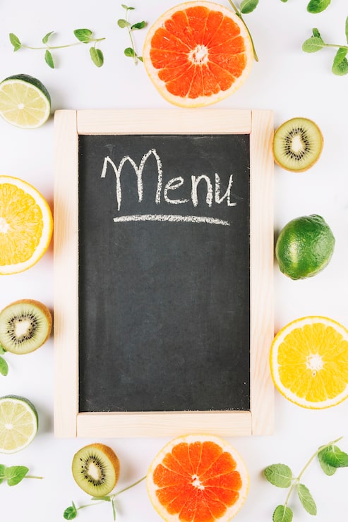 Foto gratuito frutas alrededor de la pizarra con la escritura del menú