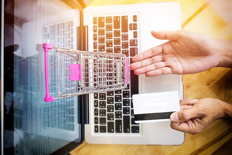 Photo Gratis gambar yang dipotong dari seorang wanita memasukkan informasi kartu dan tombol di telepon atau laptop saat berbelanja online.