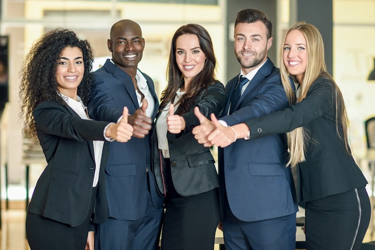 Foto gratuito grupo de empresarios con pulgares arriba gesto en la oficina moderna. multiétnica personas trabajando juntos. concepto de trabajo en equipo.