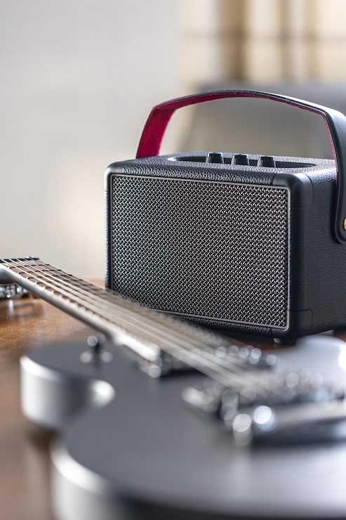 Foto gratuito guitarra eléctrica negra y altavoz en una mesa de madera