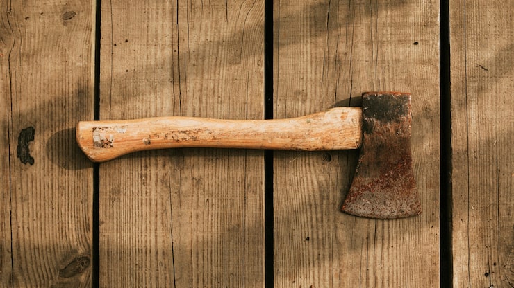 Foto gratuito hacha rústica sobre un fondo de madera flatlay