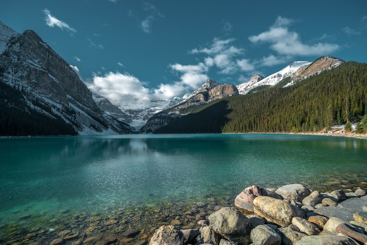 Foto gratuito una hermosa fotografía de las montañas reflejadas en el frío lago bajo el cielo nublado.