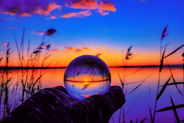 Foto gratuito hermosa toma de enfoque selectivo de una bola de cristal que refleja la impresionante puesta de sol