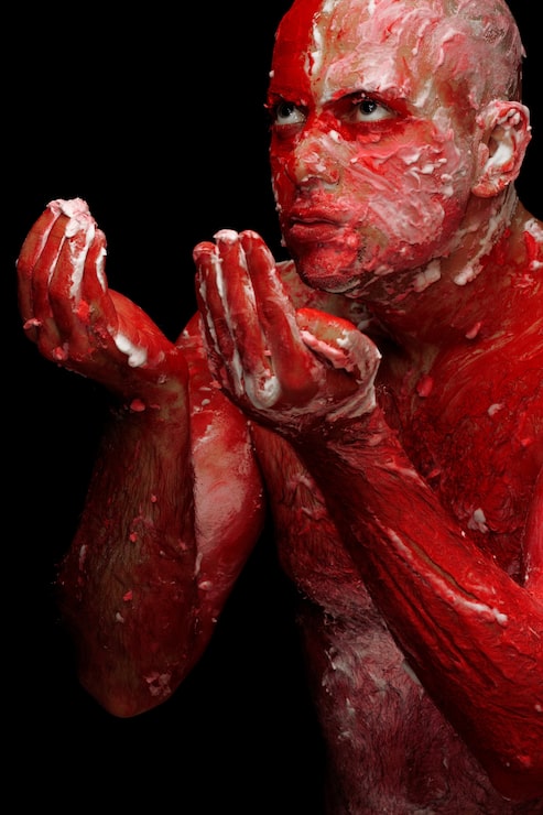 Foto gratuito hombre cubierto de pintura roja y blanca