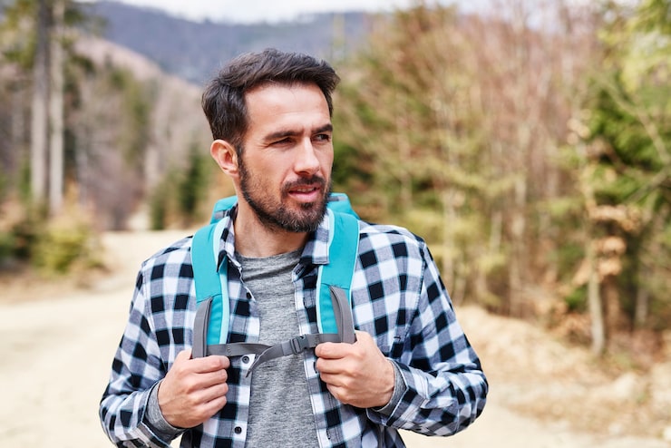 Foto gratuito hombre guapo disfrutando de la vista durante el viaje a las montañas