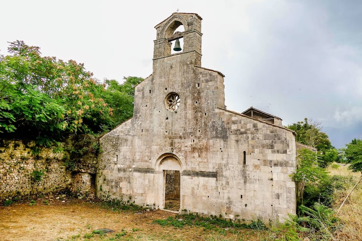 Foto gratuito iglesia cristiana rodeada de árboles en bussi, italia