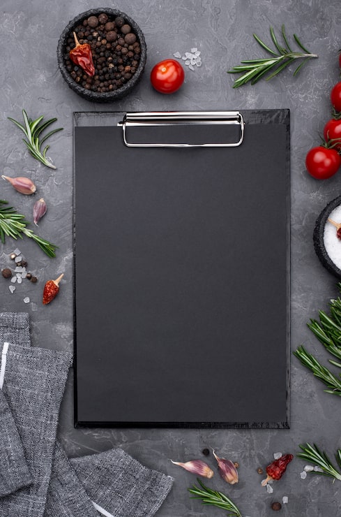 Foto gratuito ingredientes con portapapeles en mesa