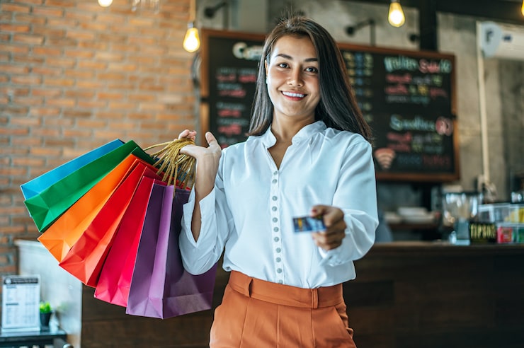 Foto gratuito joven disfruta de compras con tarjetas de crédito.