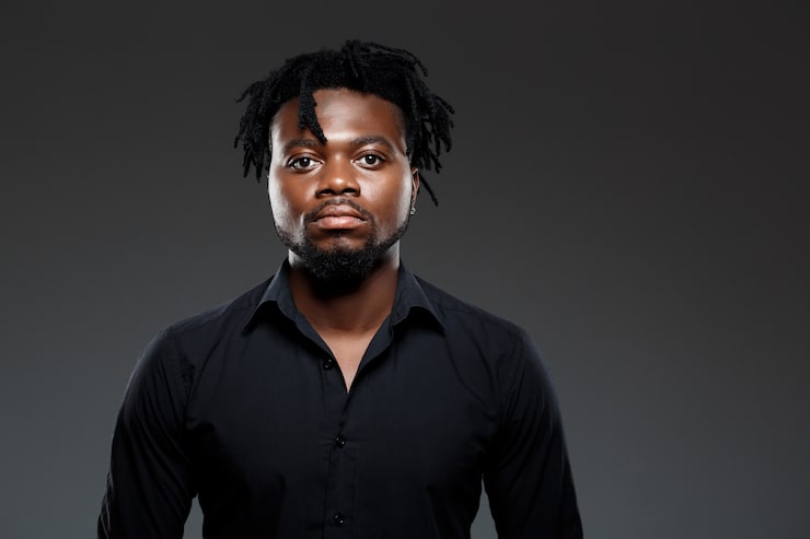 Foto gratuito joven empresario africano exitoso posando en la oscuridad