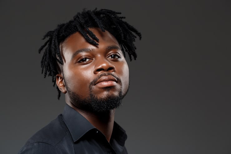 Foto gratuito joven empresario africano exitoso posando en la oscuridad