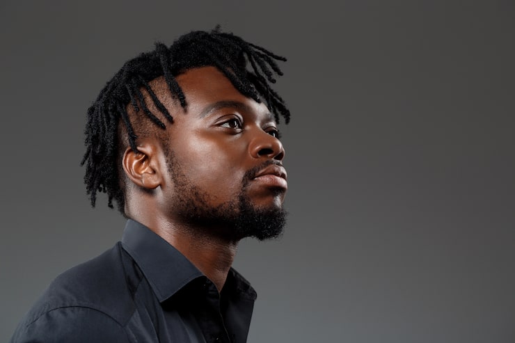 Foto gratuito joven empresario africano exitoso posando en la oscuridad
