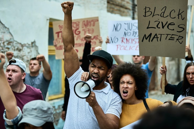 Photo Gratis kerumunan multi-etnis orang berjuang untuk kebebasan pada protes menentang diskriminasi rasial fokus pada pasangan afrika-amerika yang berteriak melalui megafon