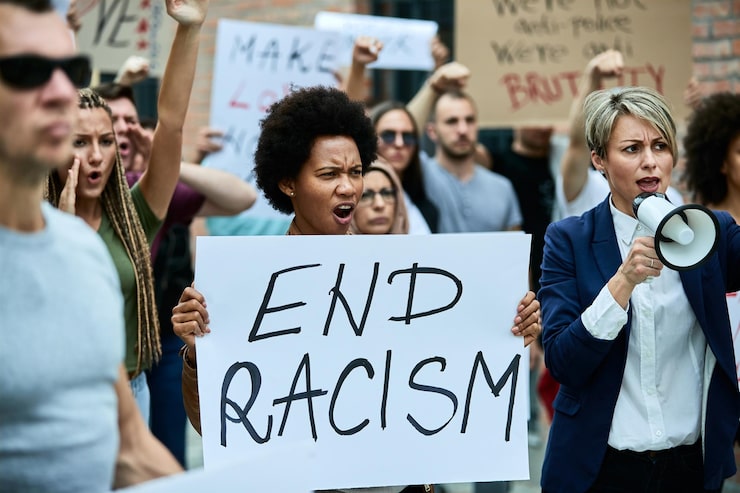 Photo Gratis kerumunan orang memprotes rasisme di jalanan. fokus pada wanita afrika-amerika yang memegang banner dengan tulisan akhiri rasisme
