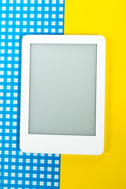 Foto gratuito lector de libros electrónicos sobre fondo amarillo y azul.