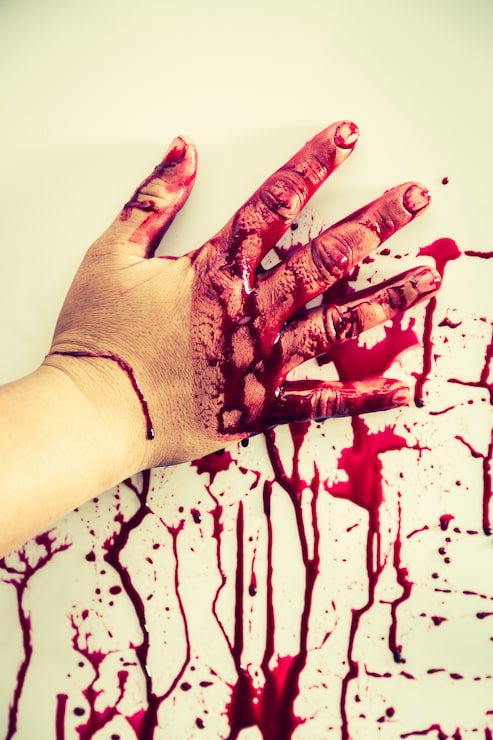 Foto gratuito mano manchada de sangre tocando una pared