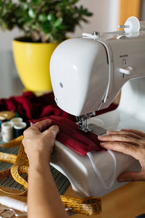 Foto gratuito manos de una mujer haciendo mascarillas de tela con máquina de coser