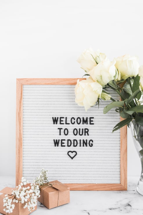 Foto gratuito marco de bienvenida para bodas con cajas de regalo y rosas sobre fondo blanco.
