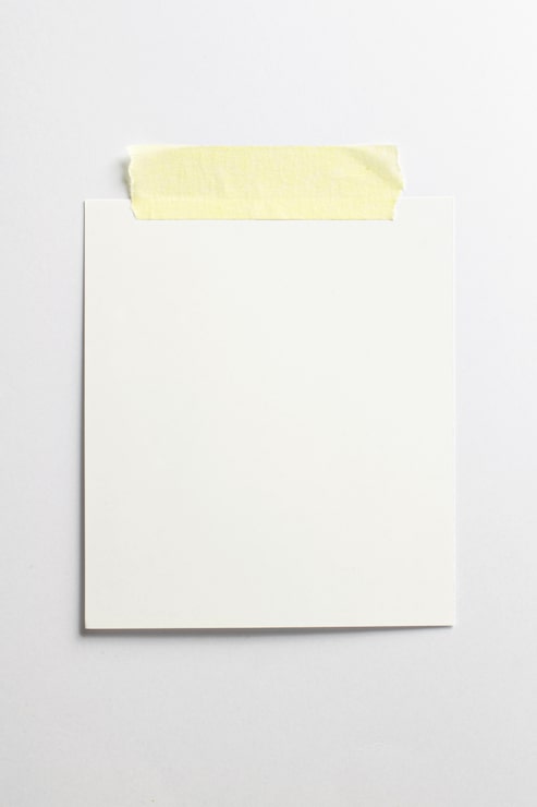 Foto gratuito marco fotográfico en blanco con sombras suaves y cinta adhesiva amarilla aislada sobre fondo de papel blanco