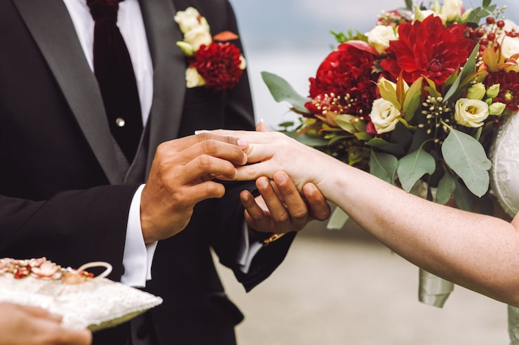 Photo Gratis mempelai pria memasangkan cincin kawin ke jari pengantin wanita