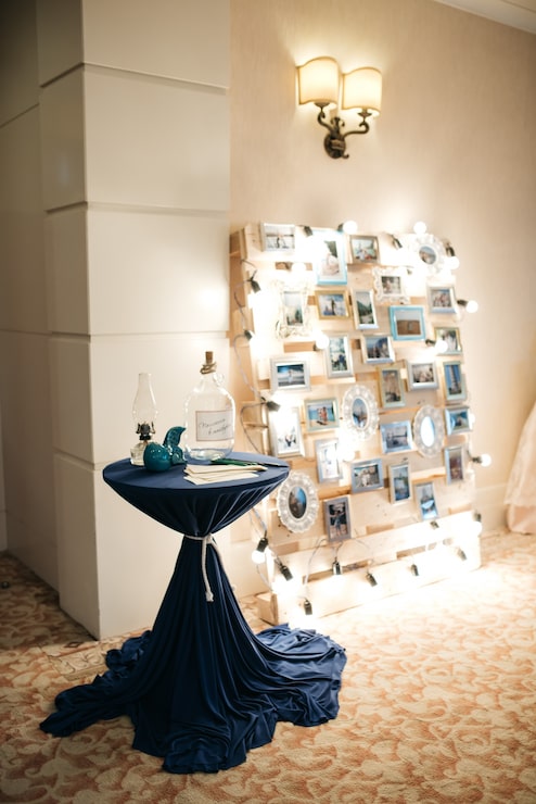 Foto gratuito la mesa azul está delante de la pared con fotos y luces