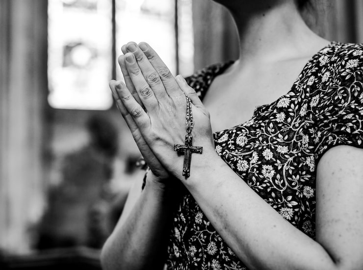 Foto gratuito mujer católica rezando con un rosario en la iglesia.