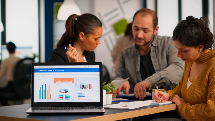 Foto gratuito mujer de negocios hablando de proyecto financiero, tomando notas, discutiendo ideas de puesta en marcha usando laptop. diversos empleados reunidos en co-working, proceso de trabajo en empresa ocupada, concepto de ayuda de trabajo en equipo